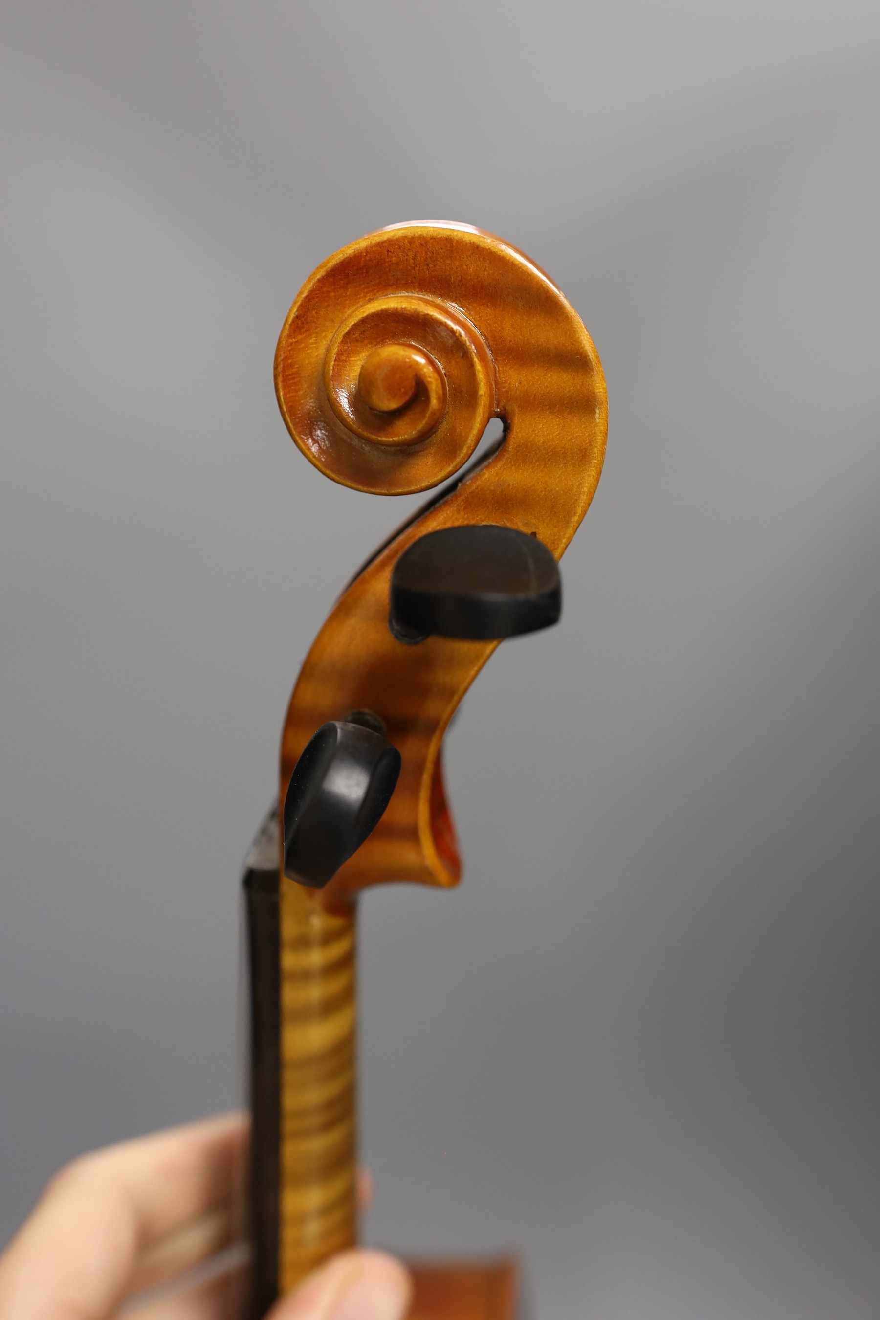 A cased child's violin and bow with ivorine tip, violin 55cms long